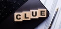 The word CLUE is written on wooden cubes on the keyboard next to the pen Royalty Free Stock Photo