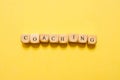 the word Coaching, text made with dice on yellow background