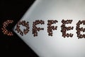 Word COFFEE Composed Of Heap of Freshly Roasted Coffee Beans and Placed Over Black and White Reflective Surface