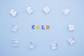 The word COLD on a blue background of wooden multicolored letters, ice cubes around the word Royalty Free Stock Photo