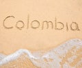 The word Colombia written in the sand on beach