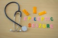 Word with colorful epileptic seizure letters on a table with a stethoscope and medicines