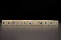 The word CONCEALMENT written on wooden cubes isolated on a black background Royalty Free Stock Photo