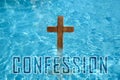 Word Confession near wooden Christian cross in water