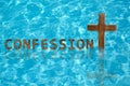 Word Confession near wooden Christian cross in water