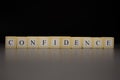 The word CONFIDENCEwritten on wooden cubes isolated on a black background Royalty Free Stock Photo