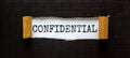 The word `confidential` appearing behind torn black paper. Business concept Royalty Free Stock Photo