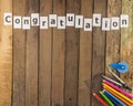 Word congratulation and stationery set on wooden