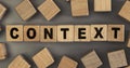 The word CONTEXT on small wooden blocks at the desk. Top view