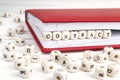 Word Contract written in wooden blocks in red notebook on white