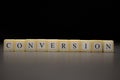 The word CONVERSION written on wooden cubes isolated on a black background