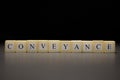 The word CONVEYANCE written on wooden cubes isolated on a black background