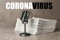 Word CORONAVIRUS, newspapers and microphone on marble table. Journalist`s work Royalty Free Stock Photo