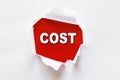 The word COST on red background behind torn white paper Royalty Free Stock Photo