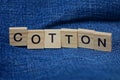 Word cotton made of wooden letters on blue fabric