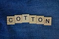 Word cotton made of wooden letters on blue fabric