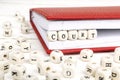 Word Court written in wooden blocks in red notebook on white woo Royalty Free Stock Photo