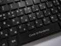 Word Covid-19 Pandemic on komputer keyboard. Selective focus.