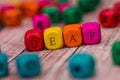 Word created with colored wooden cubes on desk.