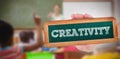 Creativity against pupils raising their hands during class Royalty Free Stock Photo
