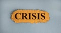 Word `crisis` on the piece of cardboard on a beautiful white background, copy space