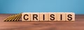 Word Crisis on wooden cube blocks on wood table with blue background. Financial crisis, investment or economic bubble burst