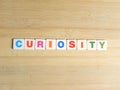 Word Curiosity on wood background