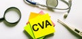 The word CVA is written on a bright sticker on a light background near a stethoscope, magnifying glass and an electronic