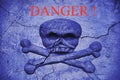 The word danger on an old cracked wall with a bas-relief of a skull and crossbones. Coronavirus infection