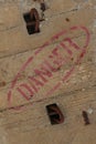 the word Danger stencilled in red paint on industrial concrete surface with rusty steel ware