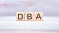 Word DBA (Database administrator) on wooden cubes on an abstract background