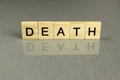 Word death, made of square wooden letters on a gray background