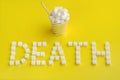 Word death from sugar cubes and disposable paper cup with straw