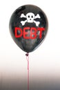 The word debt in red and a skull and cross bones on a balloon illustrating the concept of a debt bubble