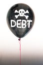 The word debt in white and a skull and cross bones on a balloon illustrating the concept of a debt bubble