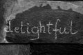 The word delightful written with chalk on black stone Royalty Free Stock Photo