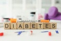Word Diabetes made with wooden cubes and syringe on table Royalty Free Stock Photo