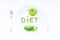 Word DIET made of green peas on a white plate with a knife and a fork Royalty Free Stock Photo