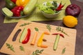 Word Diet written with different raw vegetables, fruits and greens on wooden cutting board. Organic ingredients for diet food Royalty Free Stock Photo