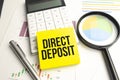 The word direct deposit is written in a notebook . Business text