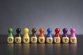 Word DIVERSITY written on wooden cubes with pawns in various colors Royalty Free Stock Photo