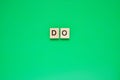 Word do. Top view of wooden blocks with letters on green surface Royalty Free Stock Photo