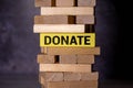the word DONATE on a yellow wooden cube and a tower of blocks