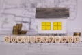 Word DOWN PAYMENT composed of wooden letters. Small paper house in the background