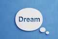 Word dream cut out in paper thought bubble floating over blue minimalistic background; 3D Illustration; new idea innovative Royalty Free Stock Photo