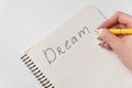 Word Dream written in the notebook. Female hand writing in notepad. Wish list Royalty Free Stock Photo