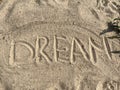 the word dream is written on the yellow river sand on the beach Royalty Free Stock Photo