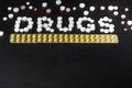 The word `drugs` is laid out of pills on a dark background with packets of pills , top view Royalty Free Stock Photo