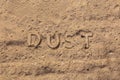 The word dust embossed on dusty road surface in flat lay perspective