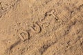 The word dust physically imprinted on dusty road surface in flat lay perspective